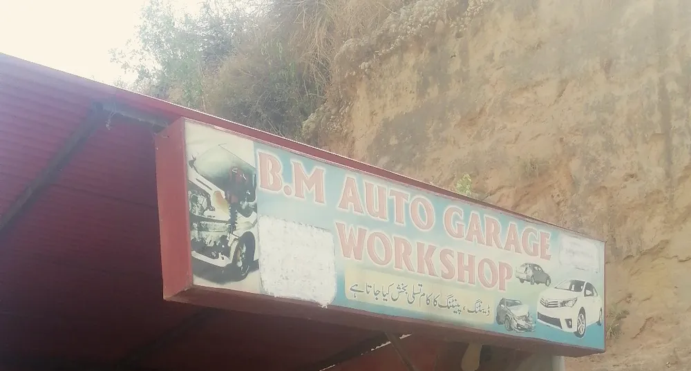 The B.M Auto Garage Workshop board, with an Urdu line about denting and painting work